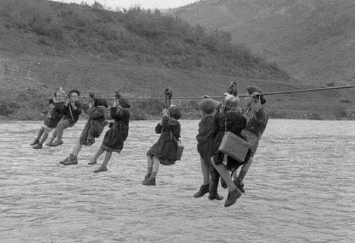 Дети идут в школу, чтобы пересечь реку на шкиве, Модена, Италия, 1959 год.