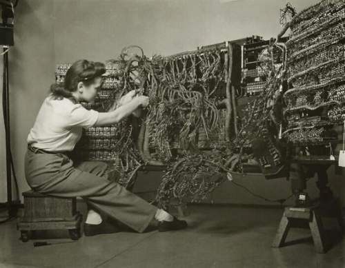 Фотография инженера, подключающего первый компьютер IBM, 1958 год. Беренис Эбботт.