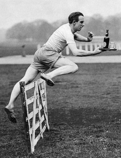 Британский барьерист Перси Ходж демонстрирует идеальный прыжок с препятствиями, неся на подносе бутылку и стакан. Перси Ходж стал олимпийским чемпионом в беге на 3000 метров с барьерами в 1920 году.